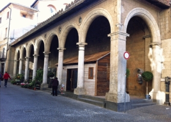 Una casetta di legno sotto il portico di Sant’Andrea